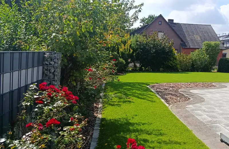 Garten mit Rosenbeet, Rasen und Terrasse