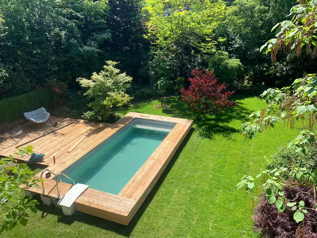 Pool mit Holzdeck im grünen Garten